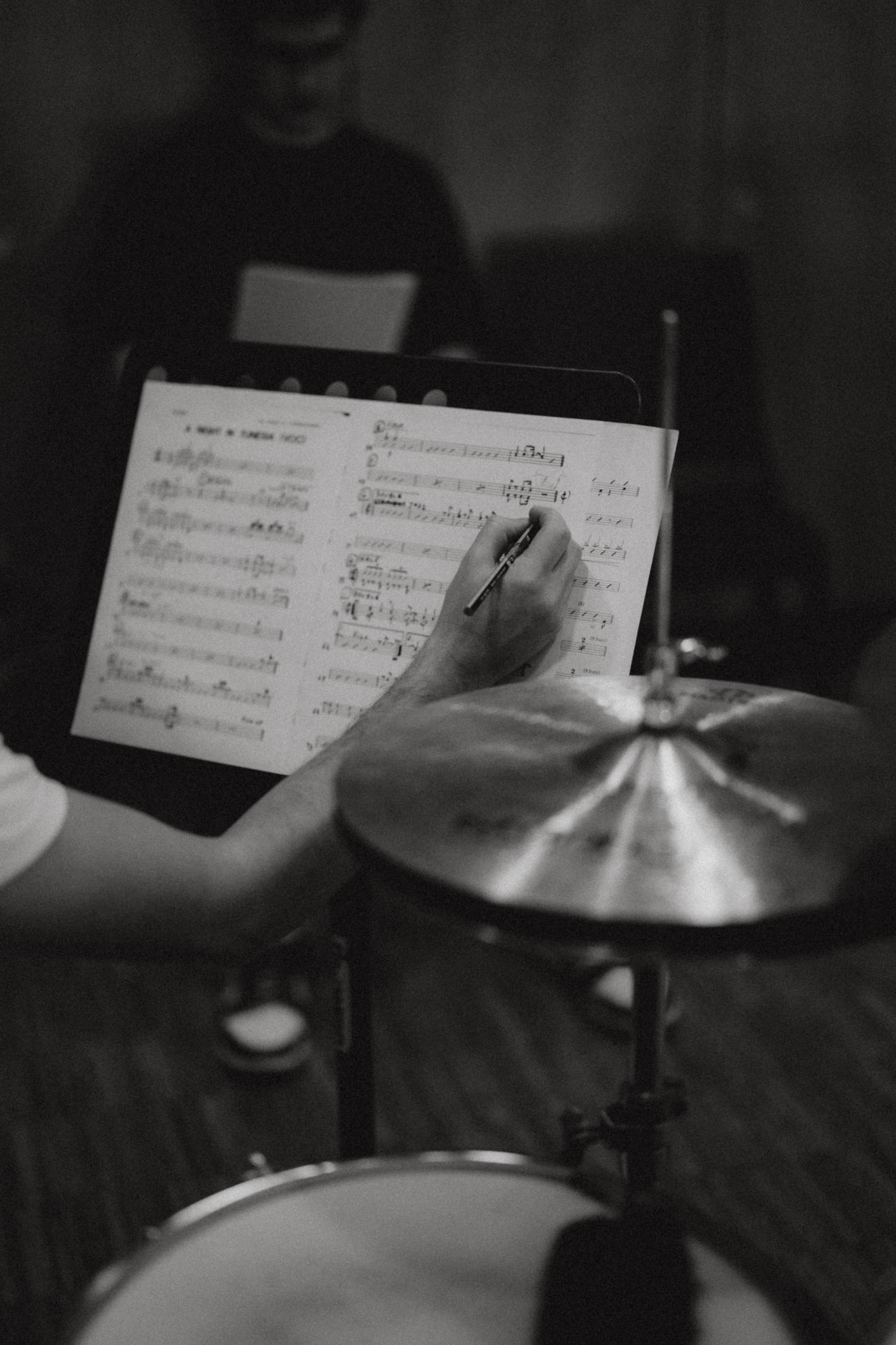 Schlagzeuger macht sich Notizen in seine Noten.