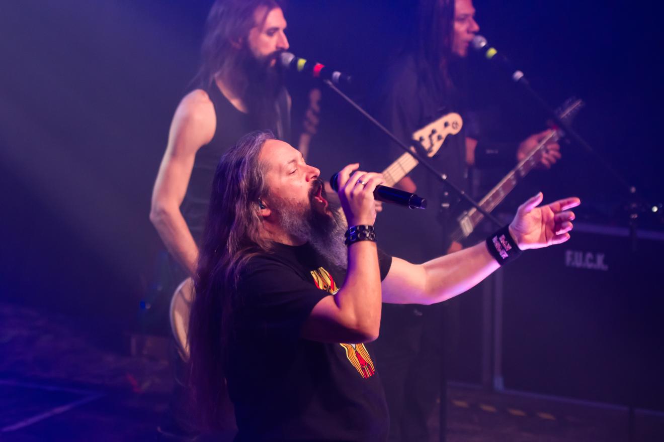 Daniel steht neben seinen Bandkollegen und performt.