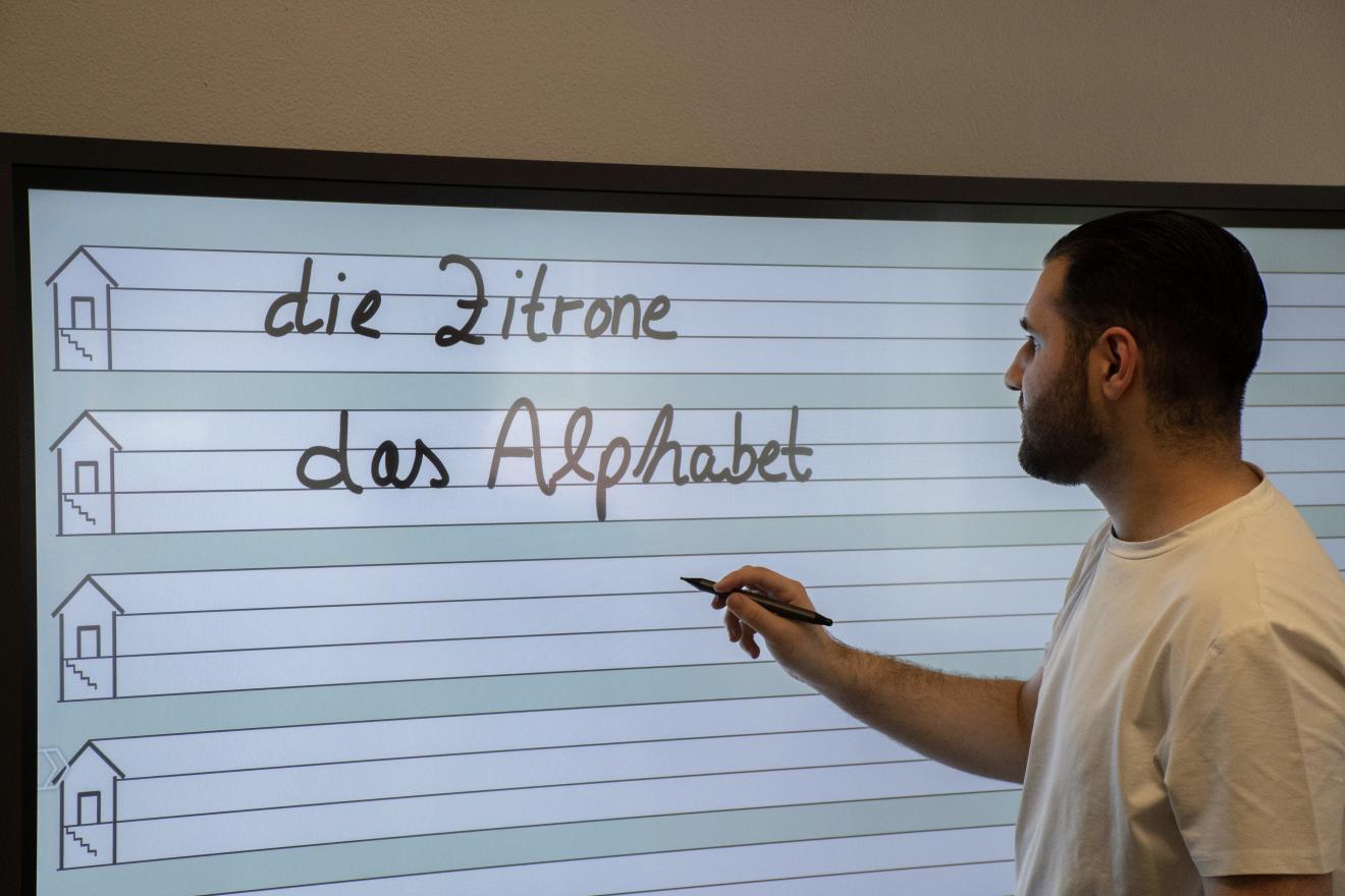 Lehrer schreibt auf Whiteboard