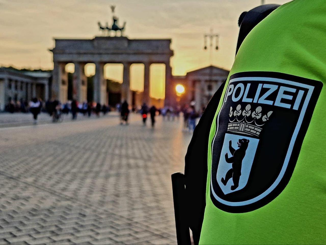 Der Arm eines Beamten der Polizie Berlin vor dem Brandenburger Tor