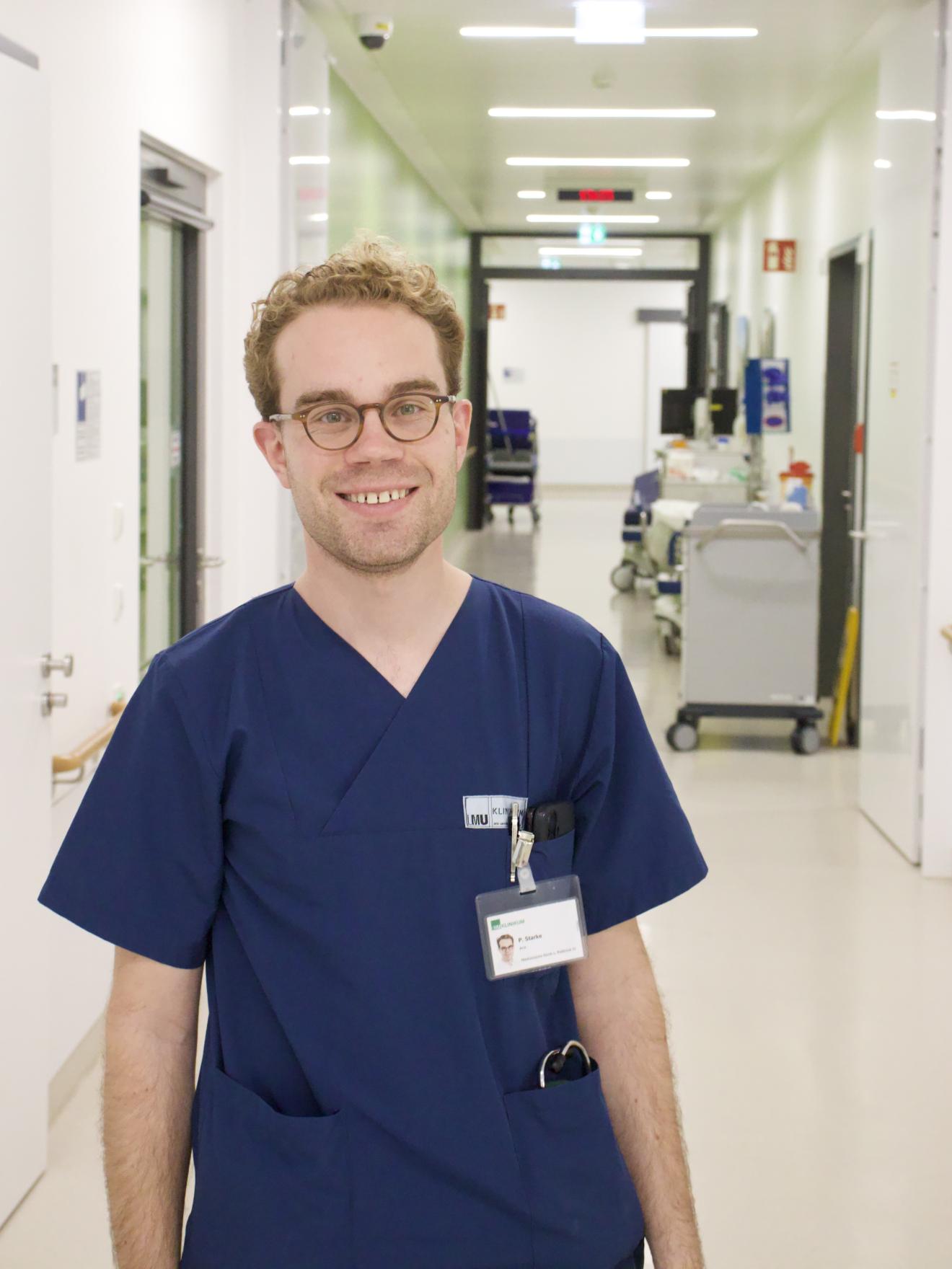 Phillip im Gang der Notaufnahmestation, mit einem Lächeln auf dem Gesicht