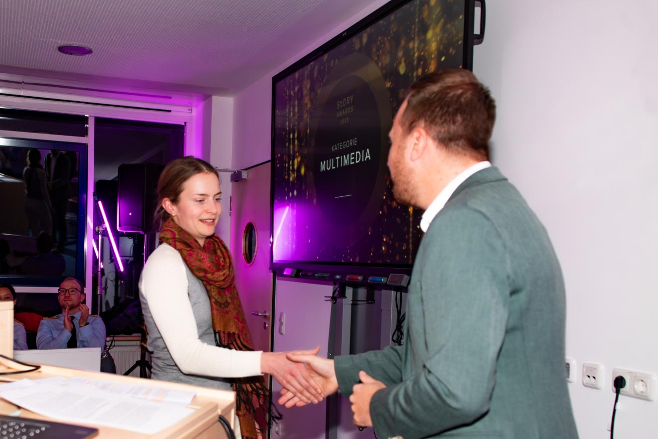 Professor Jonas Schützeneder gratuliert der Gewinnerin des 2. Platzes. 