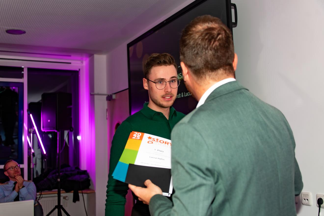 Professor Jonas Schützeneder übergibt den 1. Preis. 