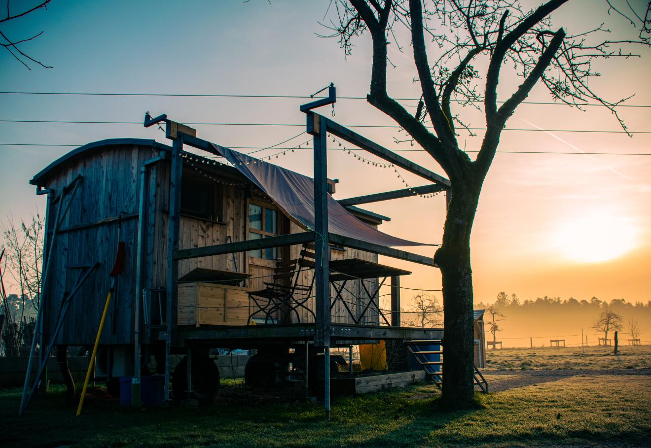 Ein mobiles Tiny House im Sonnenaufgang. 