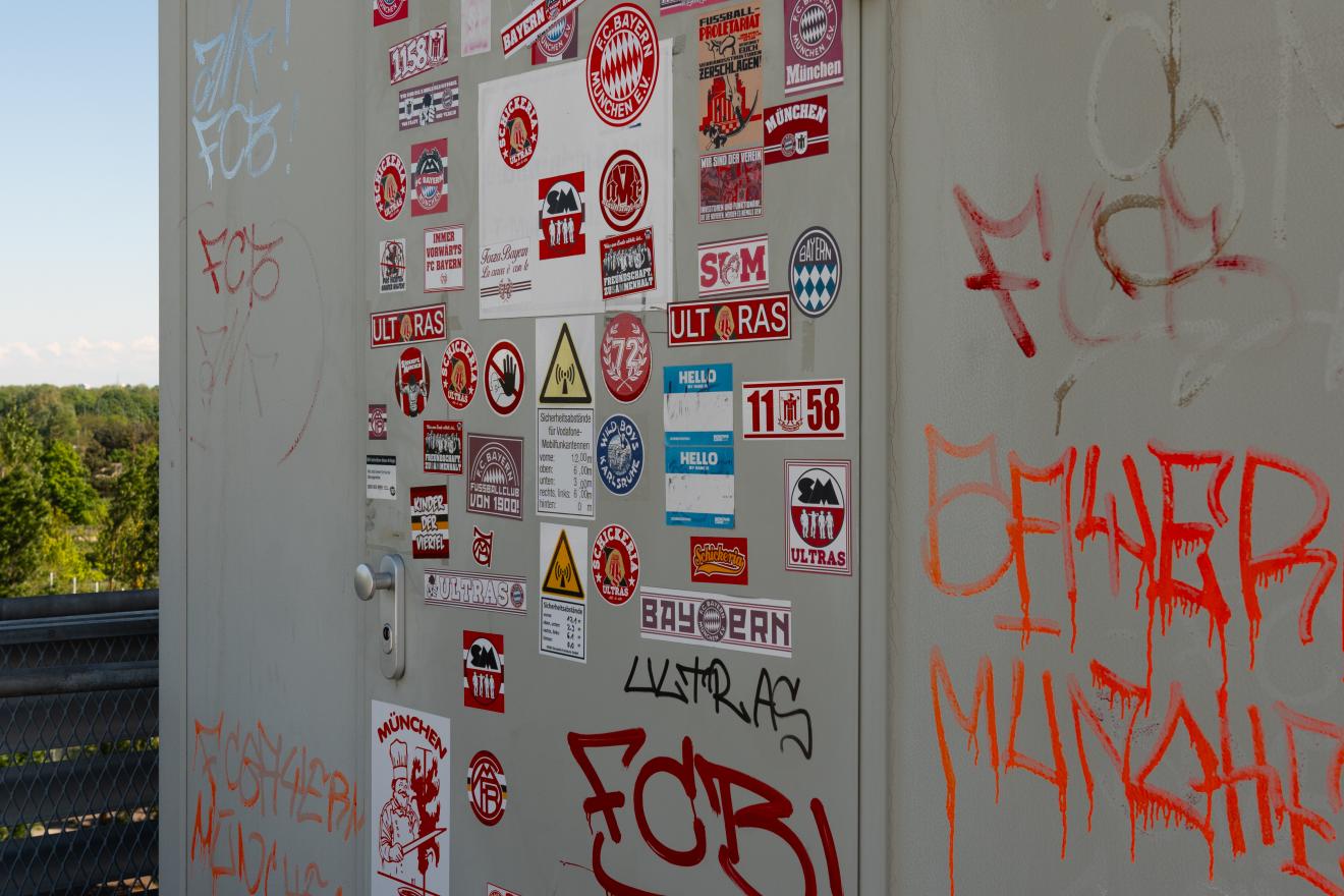 Eine Wand die mit vielen FC Bayern Stickern beklebt ist.