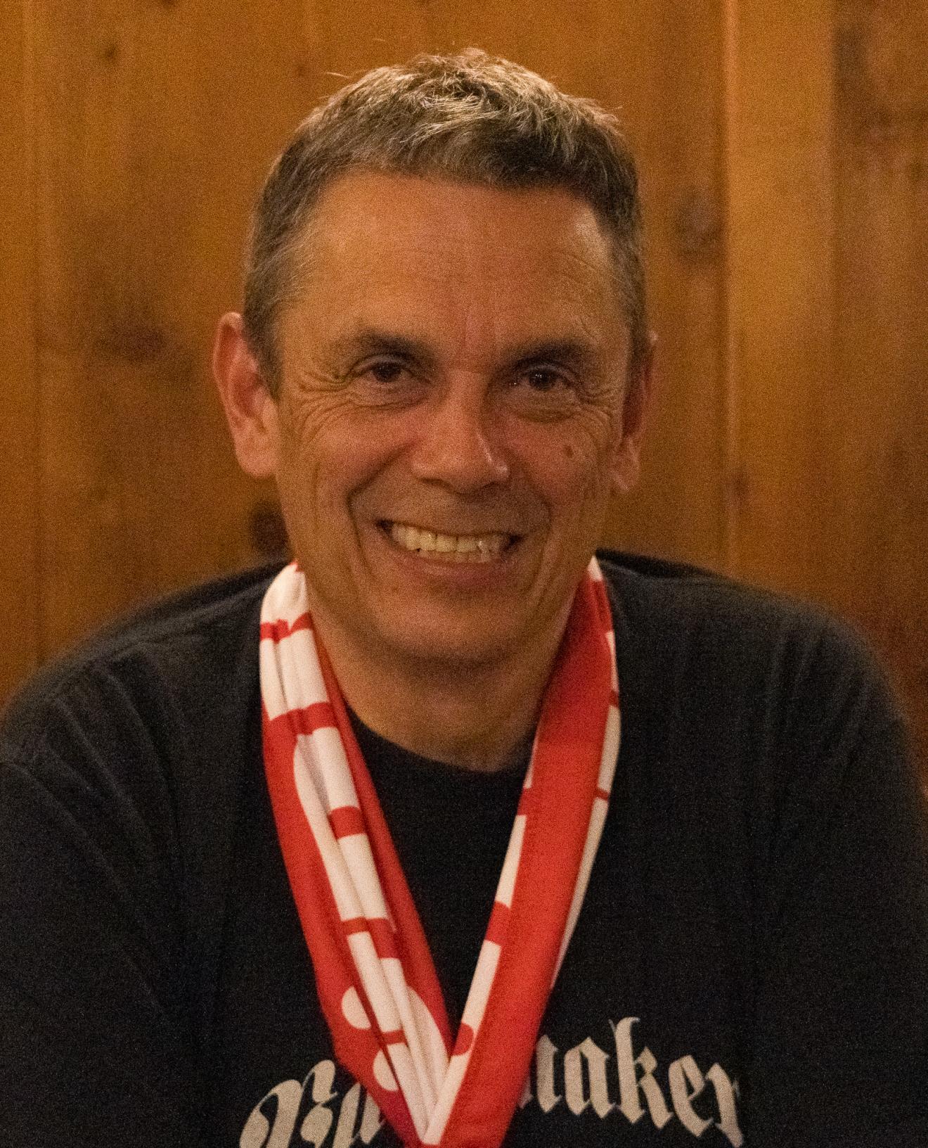 Ingo, ein Mann mitllern Alters der ein Fanschal des Fc Bayern trägt.