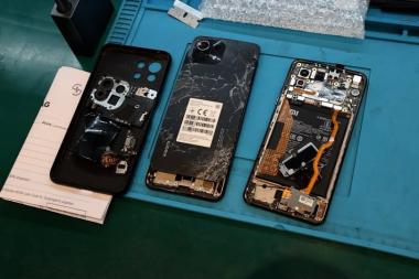 Kaputte Smartphones liegen geöffnet auf einem Tisch, die Hülle wurde abmontiert.