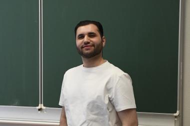 Lehrer steht vor der Tafel im Portrait