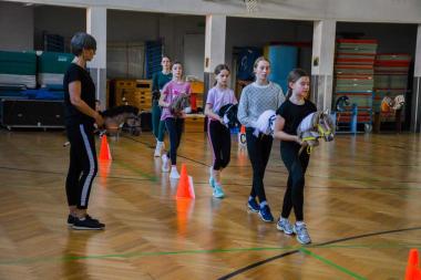 Kinder mit Steckenpferden beim Dressurtraining