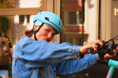 Eine Frau post mit ihrem Fahrrad draußen vor einem Kaffee