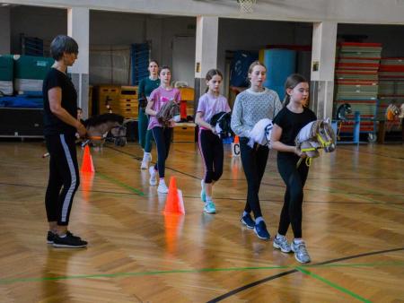 Kinder mit Steckenpferden beim Dressurtraining
