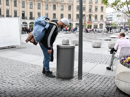 Autor Max Strote schaut in einem Mülleimer nach Pfandflaschen
