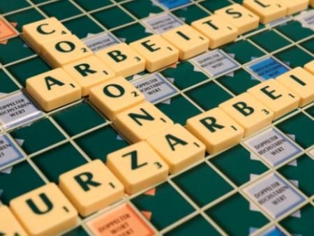 Scrabbleboard, auf dem die Worte Corona, Arbeitsmarkt und Kurzarbeit zu lesen sind